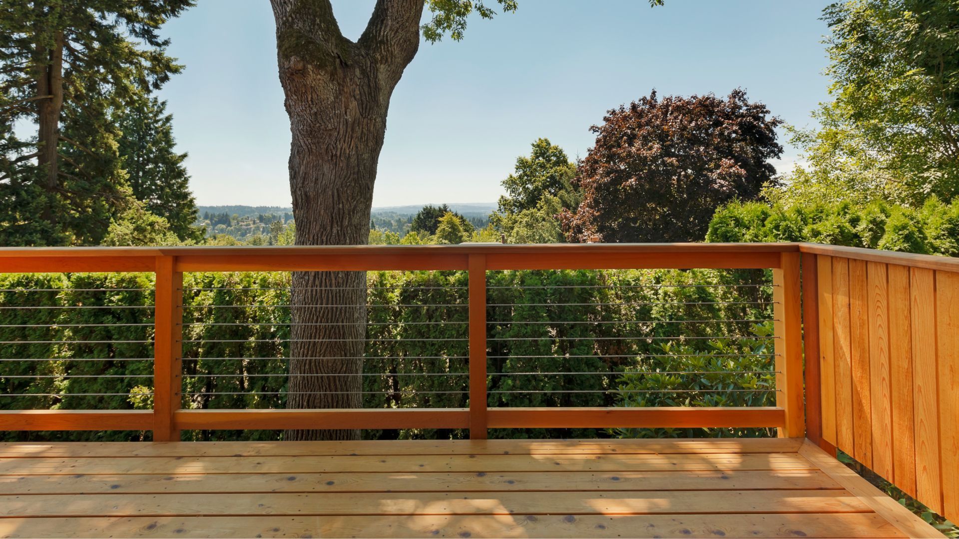 Wooden deck with orange railing overlooking lush greenery and hills in Salinas, CA.