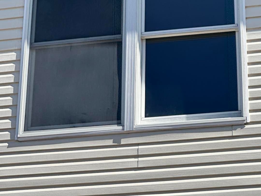 White framed window with a dirty left pane and a clean, reflective right pane.