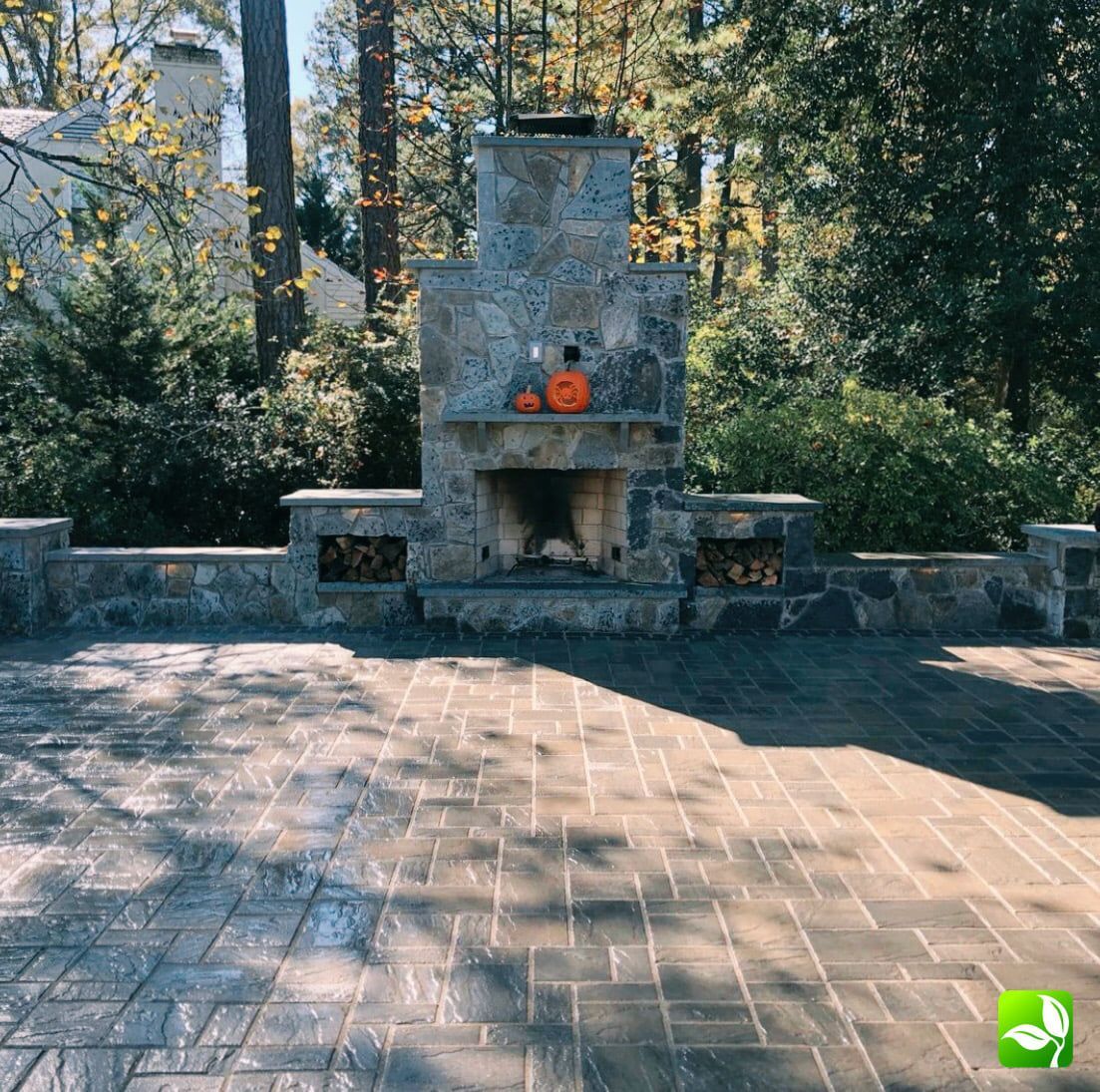 A stone fireplace with pumpkins on top of it