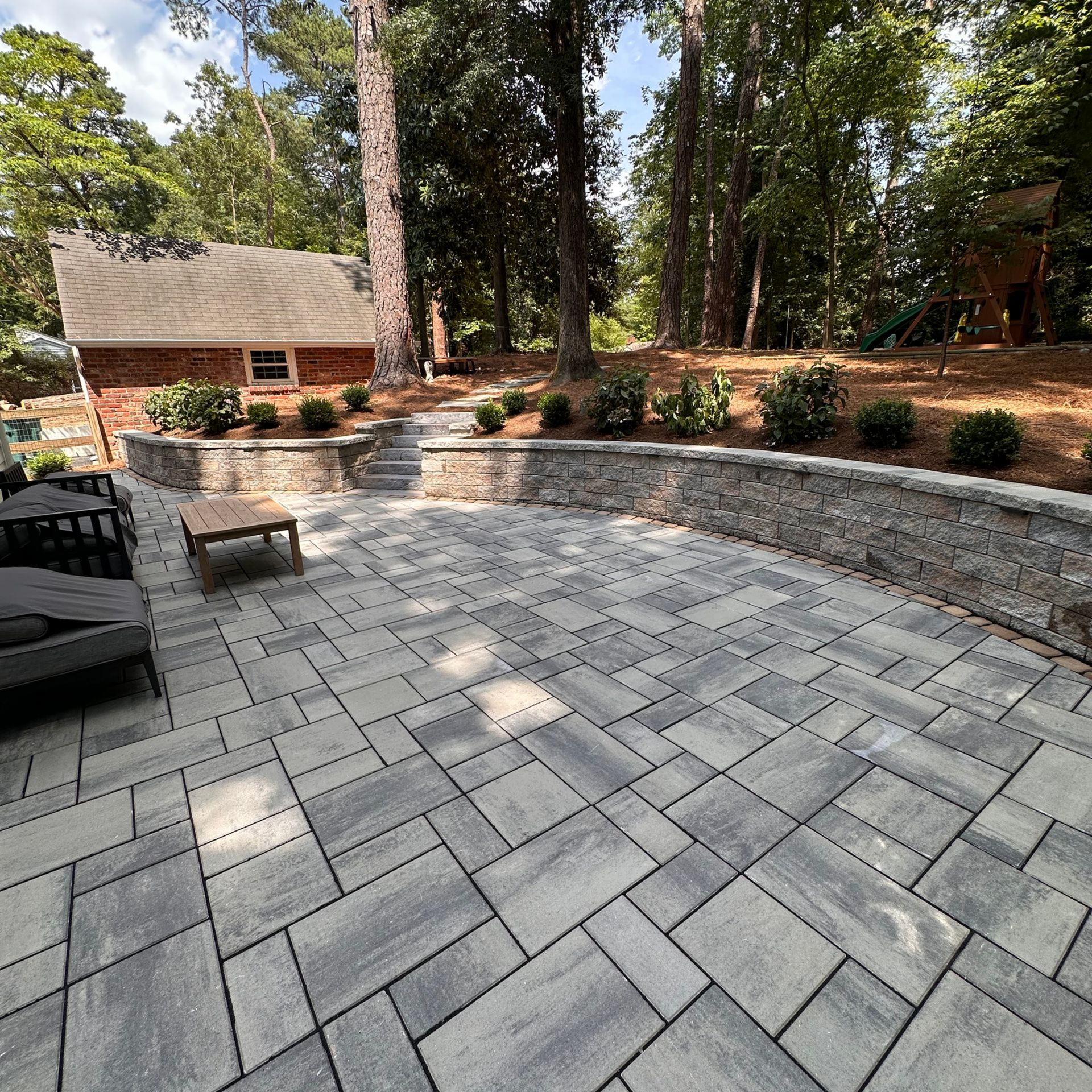 A stone wall is surrounded by gravel and grass - Hanover, VA - Hanover Landscapes