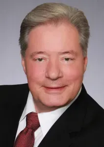 A man in a suit and tie is smiling for the camera.