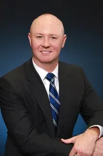 A man in a suit and tie is posing for a picture.