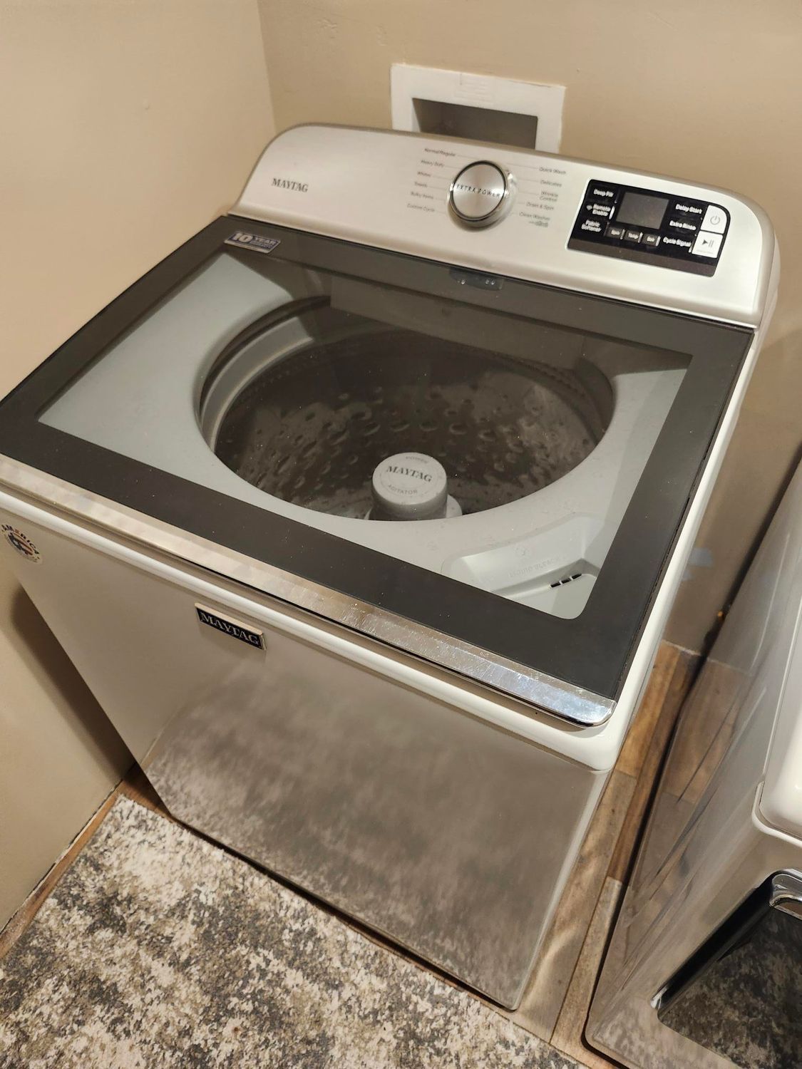 A person is fixing a stove with a screwdriver.