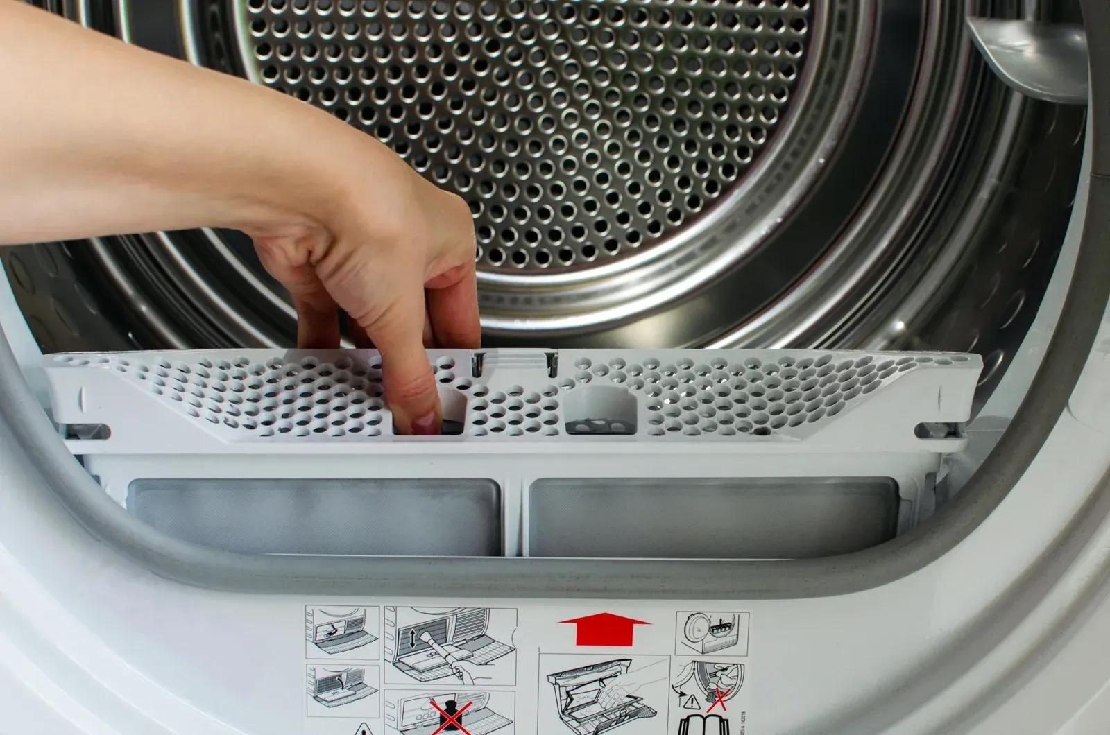 A person is opening the door of a washing machine.