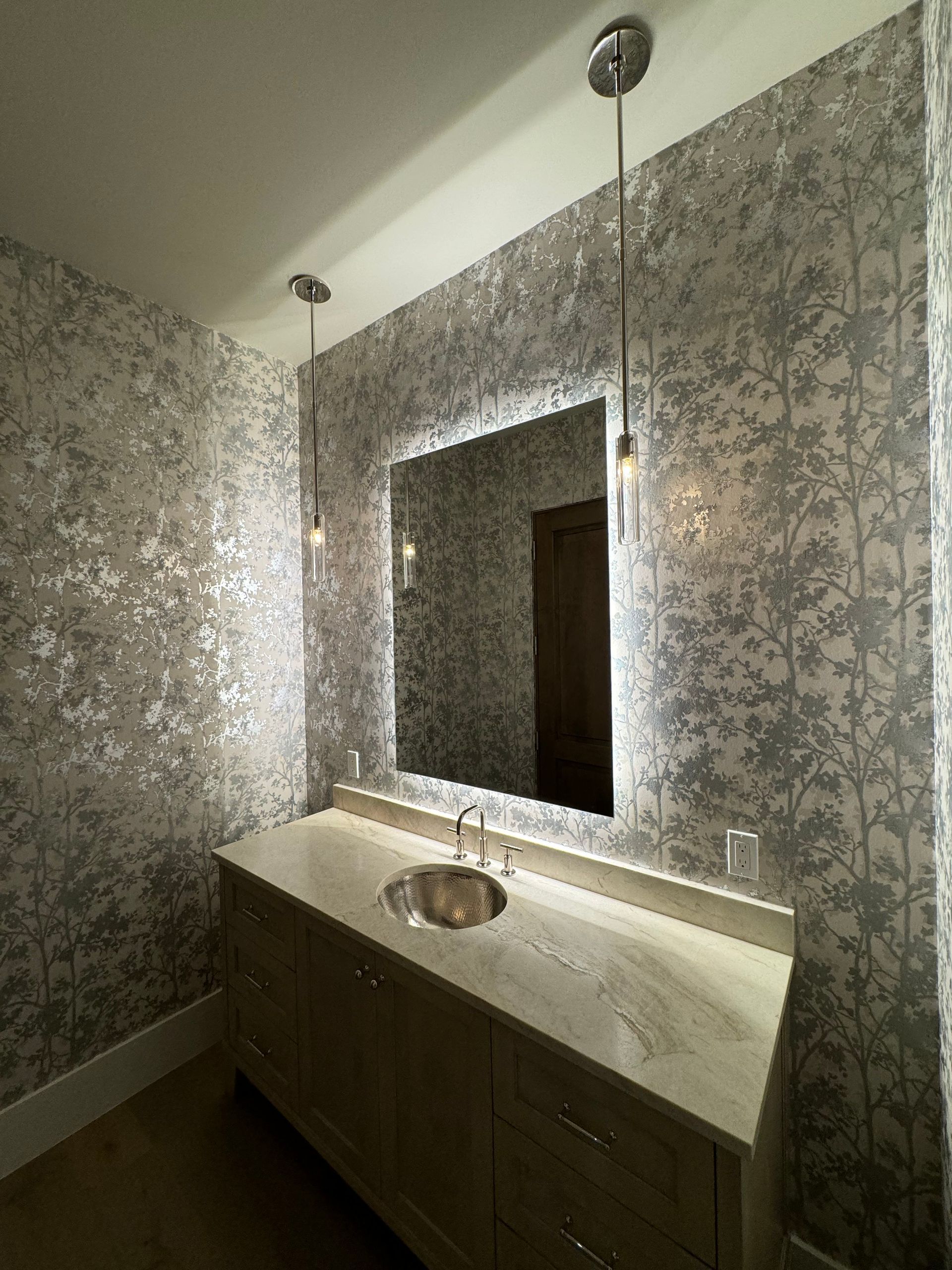 A bathroom with a sink and a large mirror.