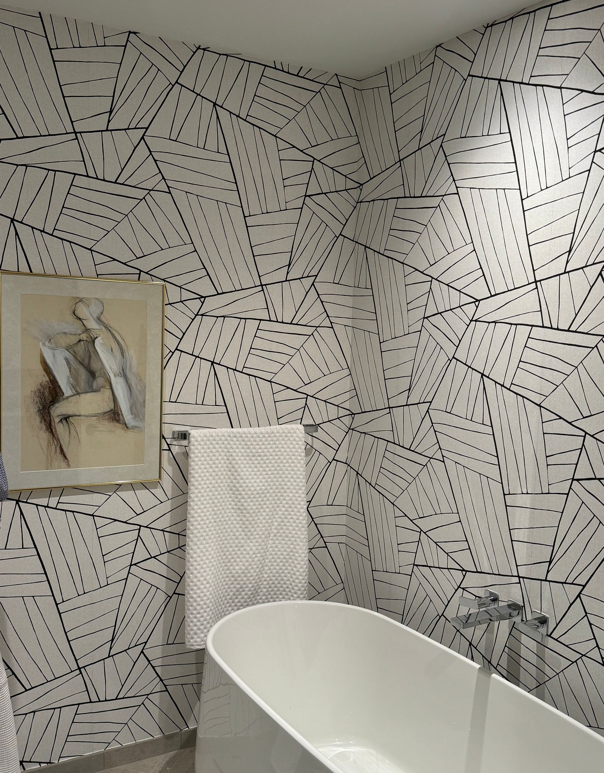 A bathroom with a bathtub and a painting on the wall