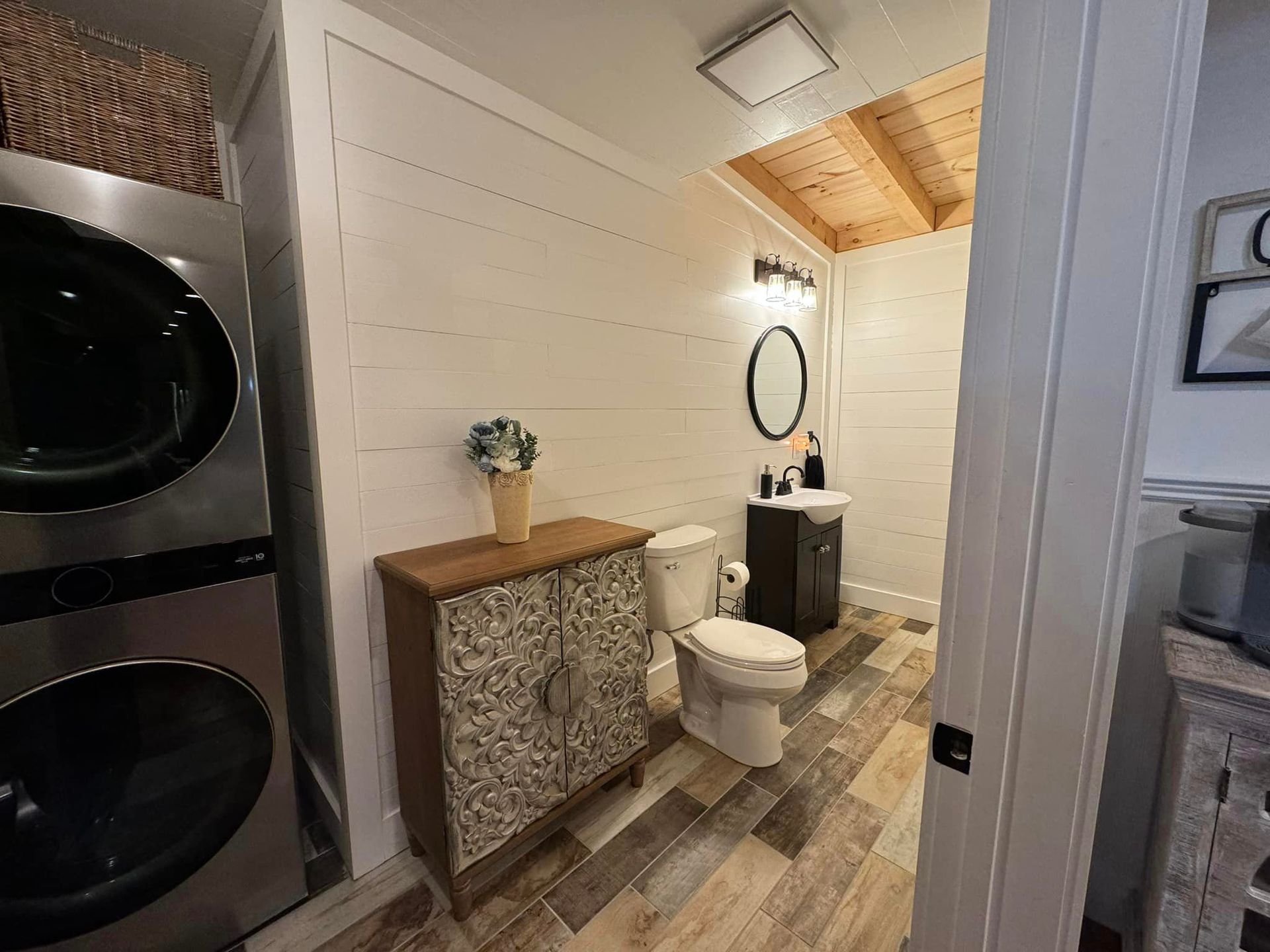 A bathroom with a toilet , sink and washer and dryer.