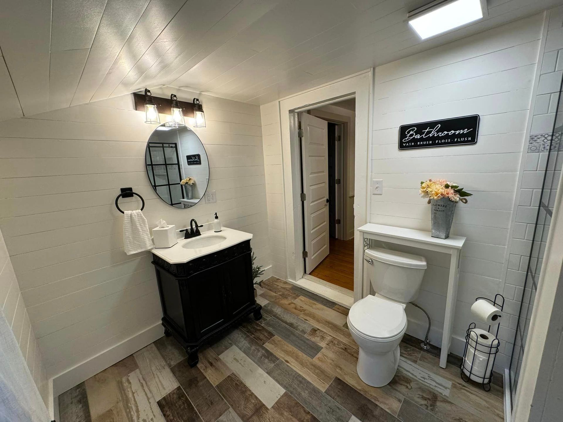 A bathroom with a toilet , sink and mirror.