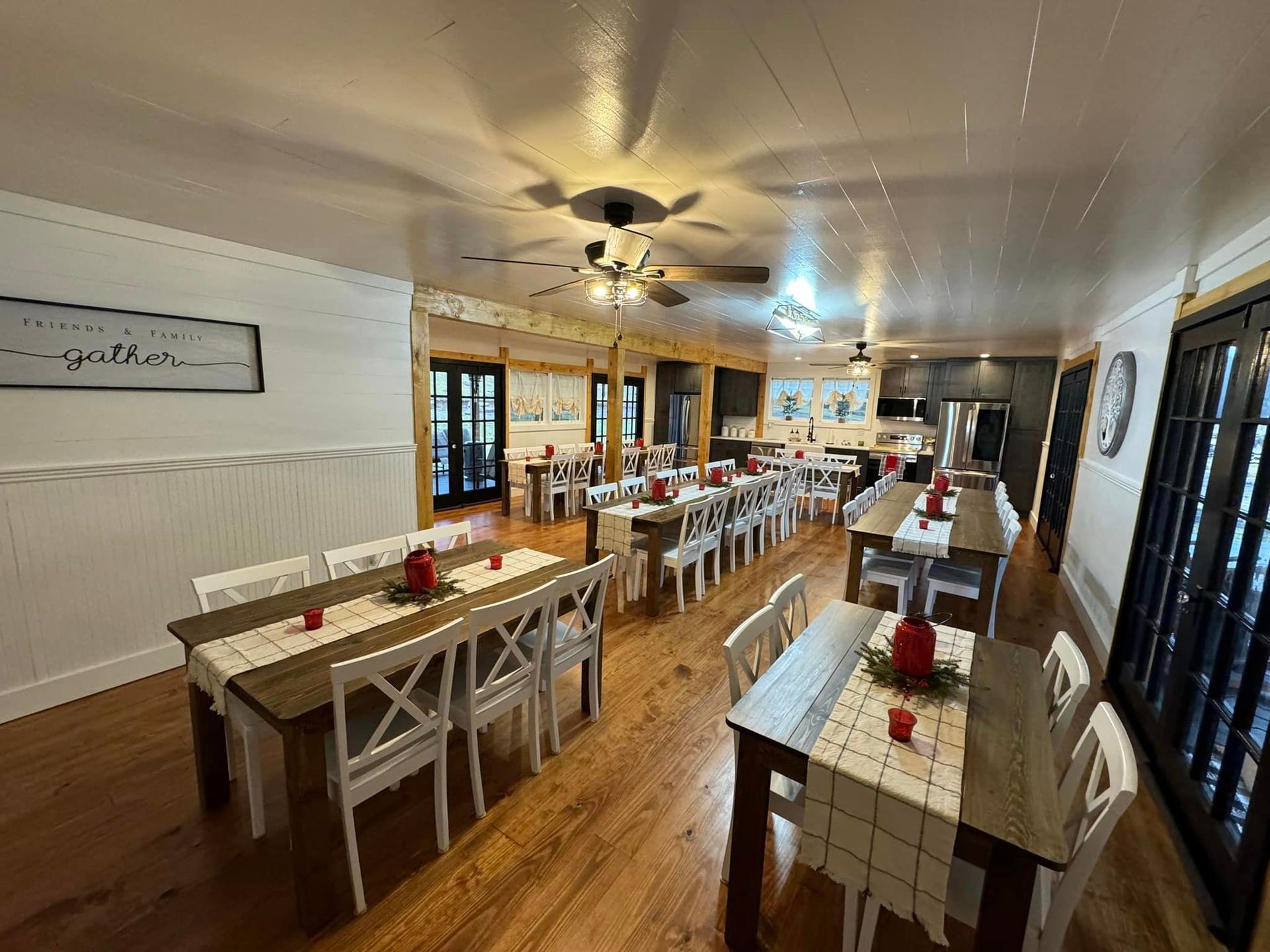 A large dining room with tables and chairs and a ceiling fan.