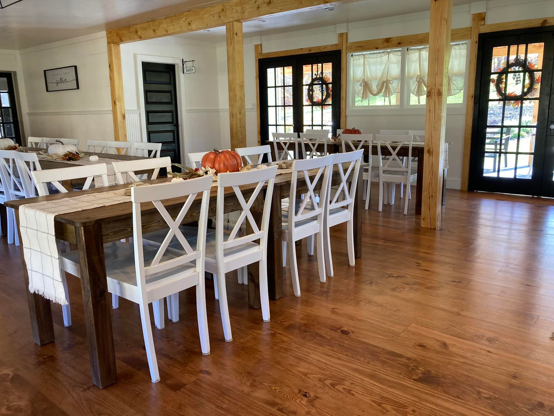 A large dining room with a table and chairs and a pumpkin on the table.