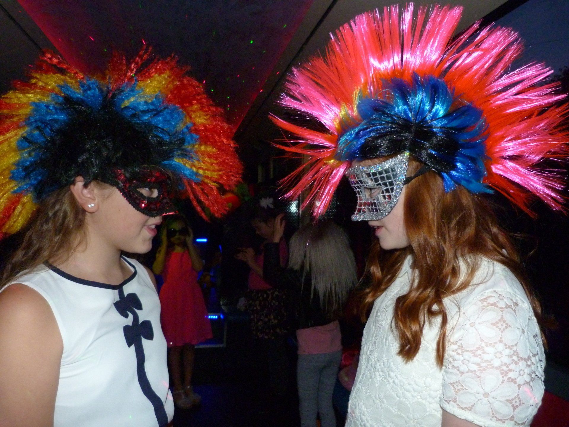 Two girls wearing masks and wigs are standing next to each other