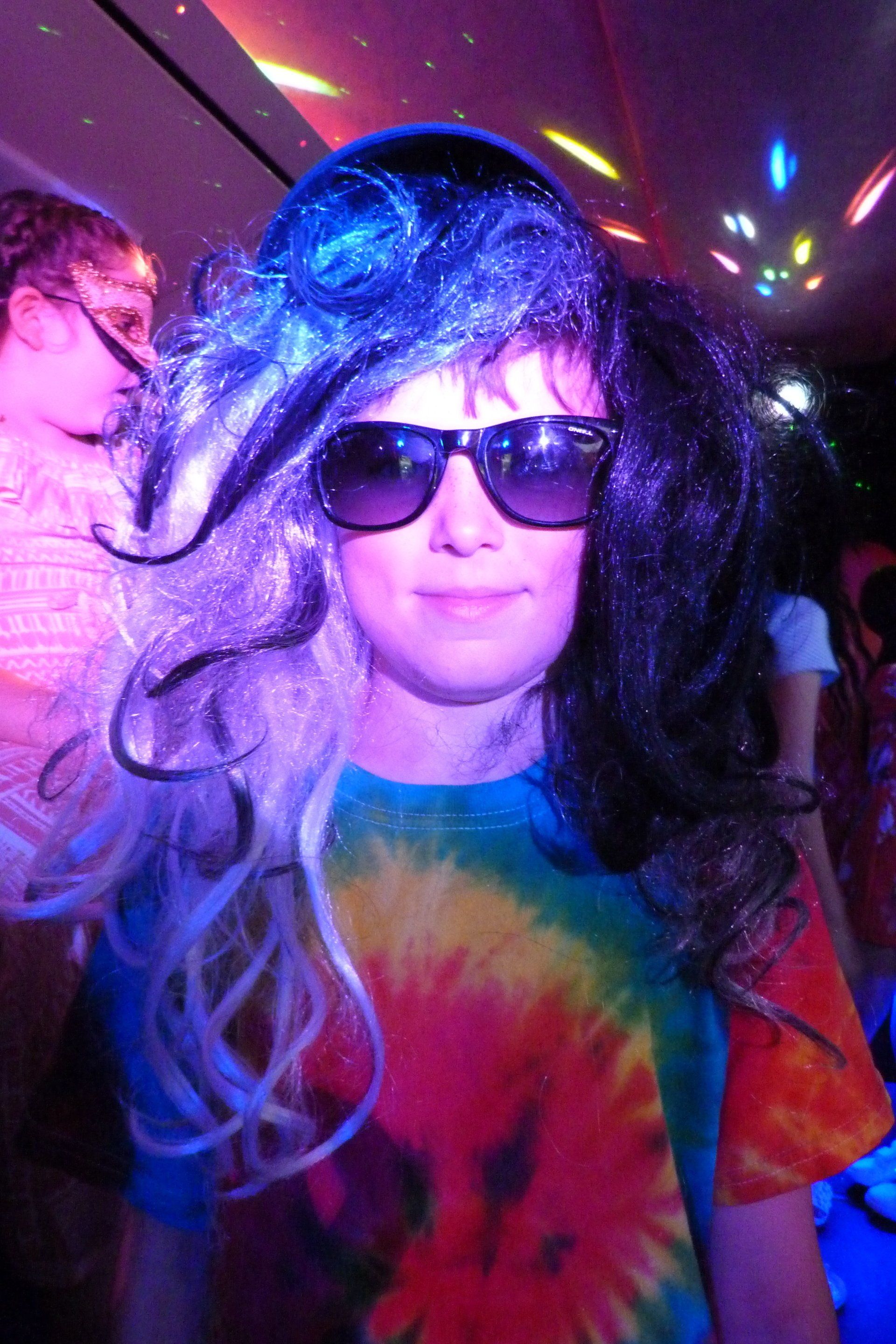 A person wearing sunglasses and a tie dye shirt