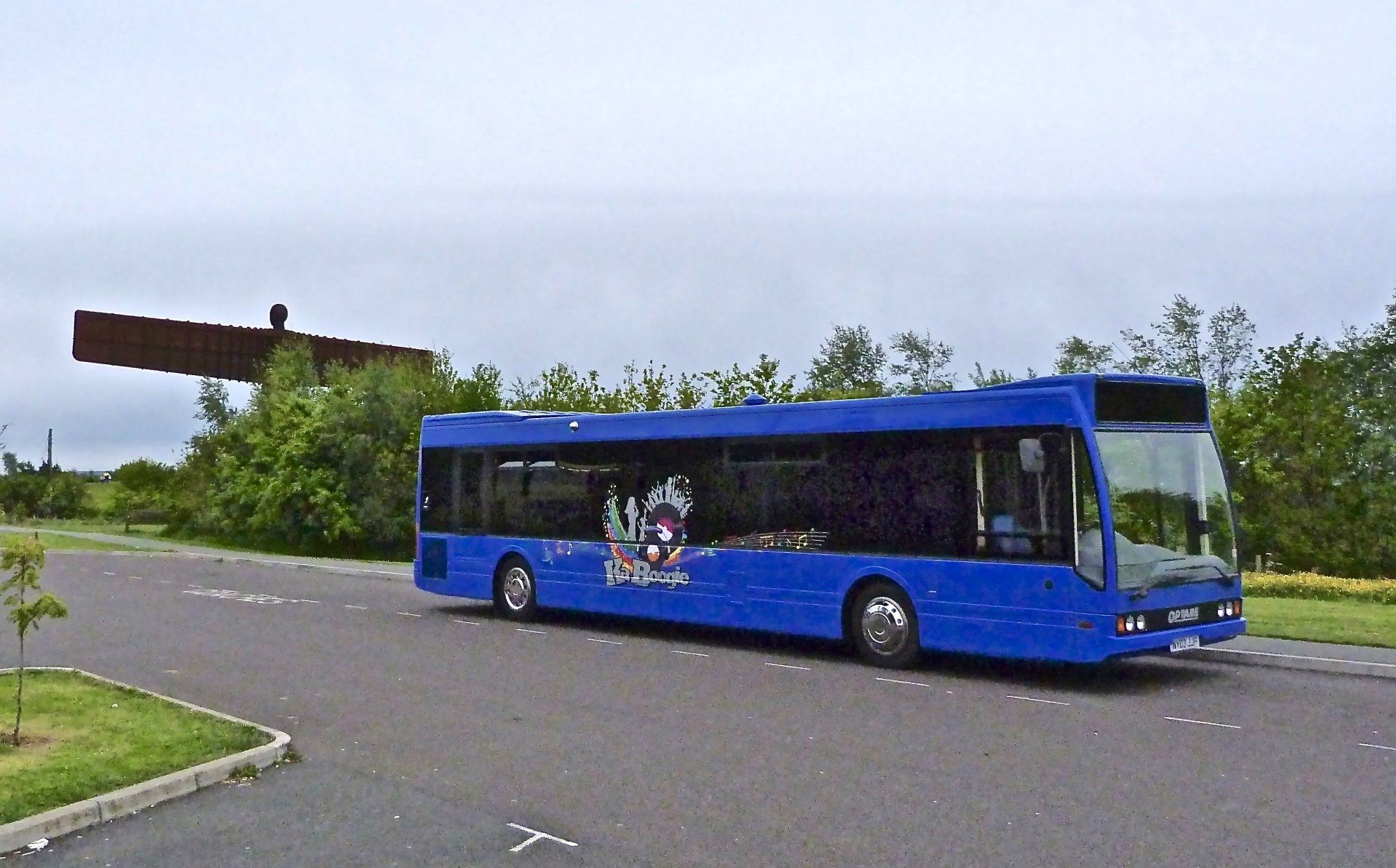 A blue bus is parked on the side of the road