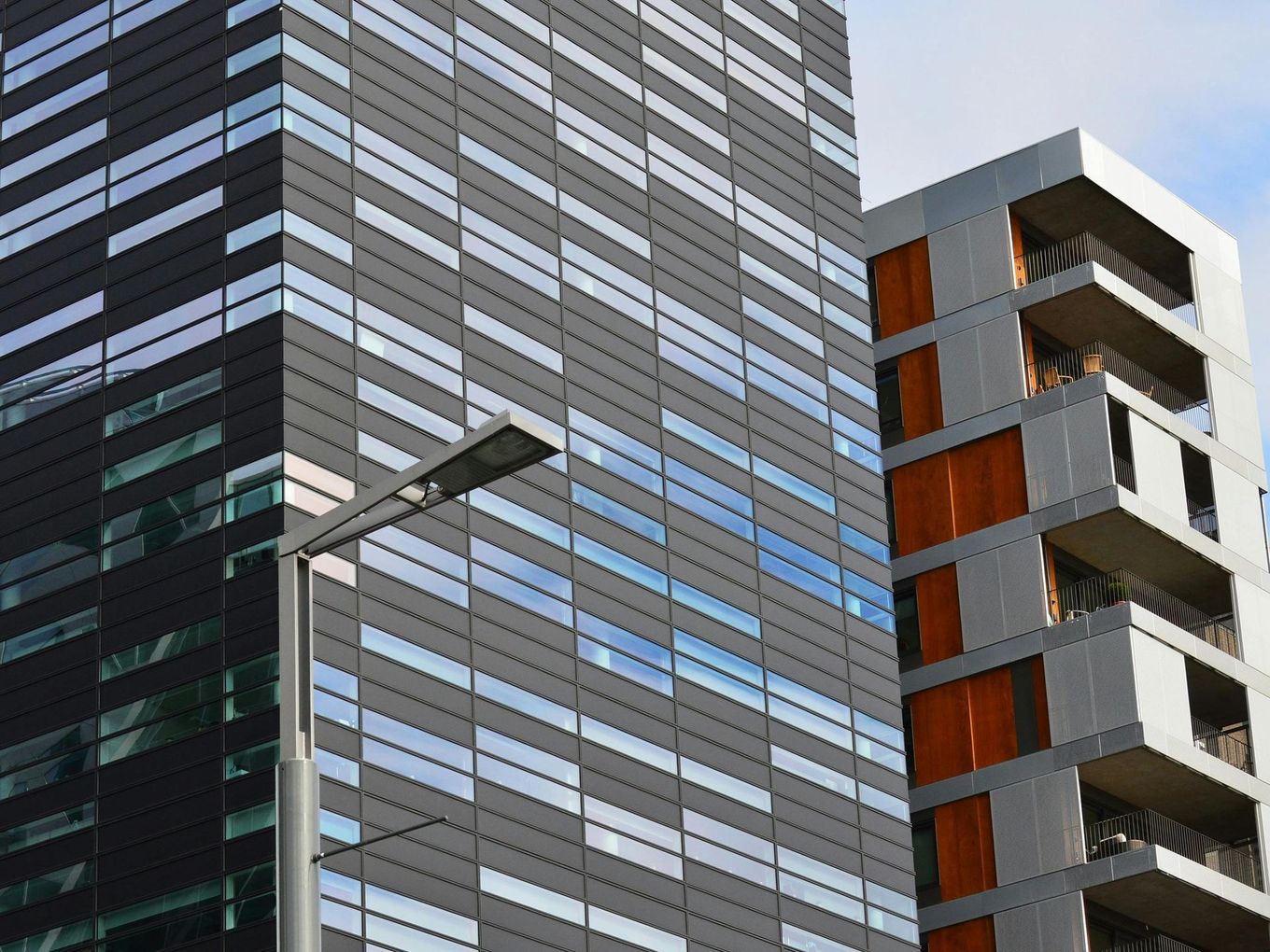 Modern buildings with rows of rectangular windows, gray and orange accents.