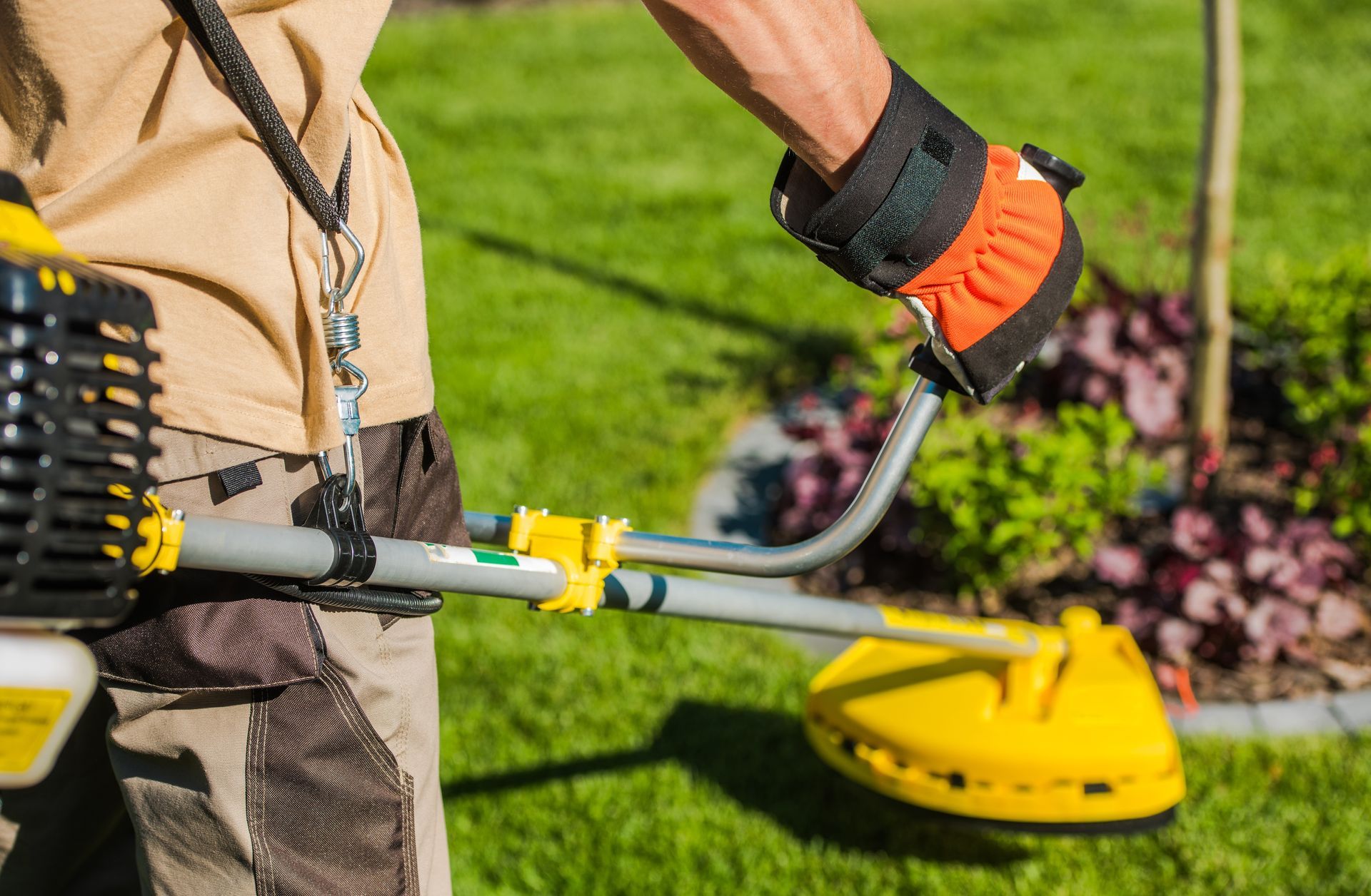 A man is using a lawn mower to cut the grass.