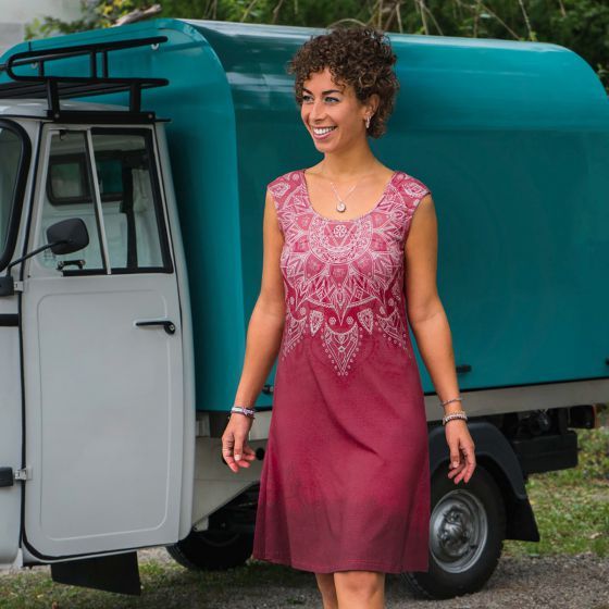 Eine Frau in einem roten Kleid steht vor einem blauen Lastwagen