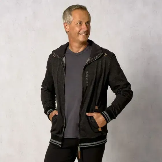 Ein Mann mit den Händen in den Taschen und einer schwarzen Jacke