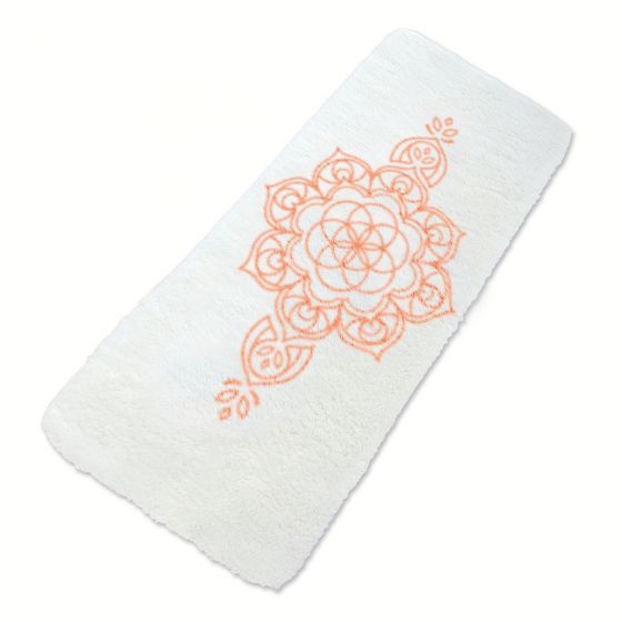 Ein weißes Handtuch mit einem orangefarbenen Blumenmuster darauf.