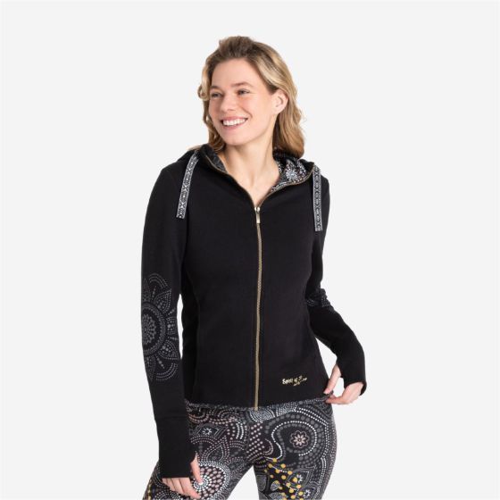 Eine Frau trägt einen schwarzen Kapuzenpullover und Leggings