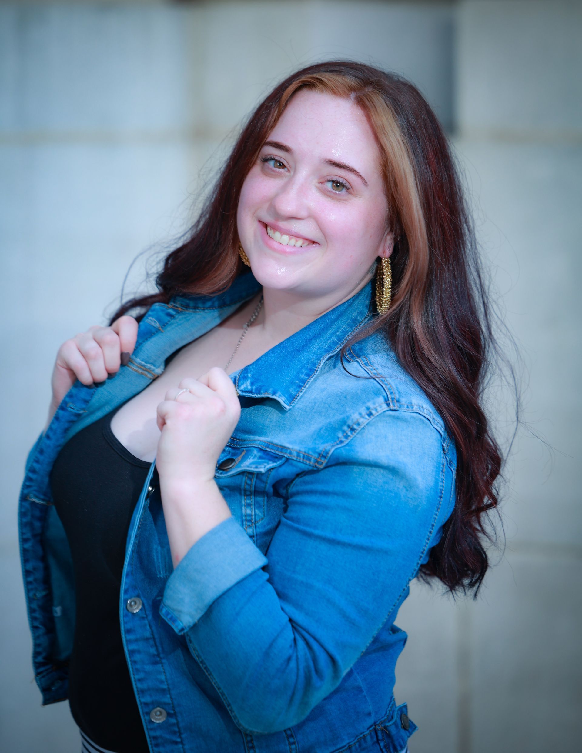 Michala is wearing a blue denim jacket and a black tank top.