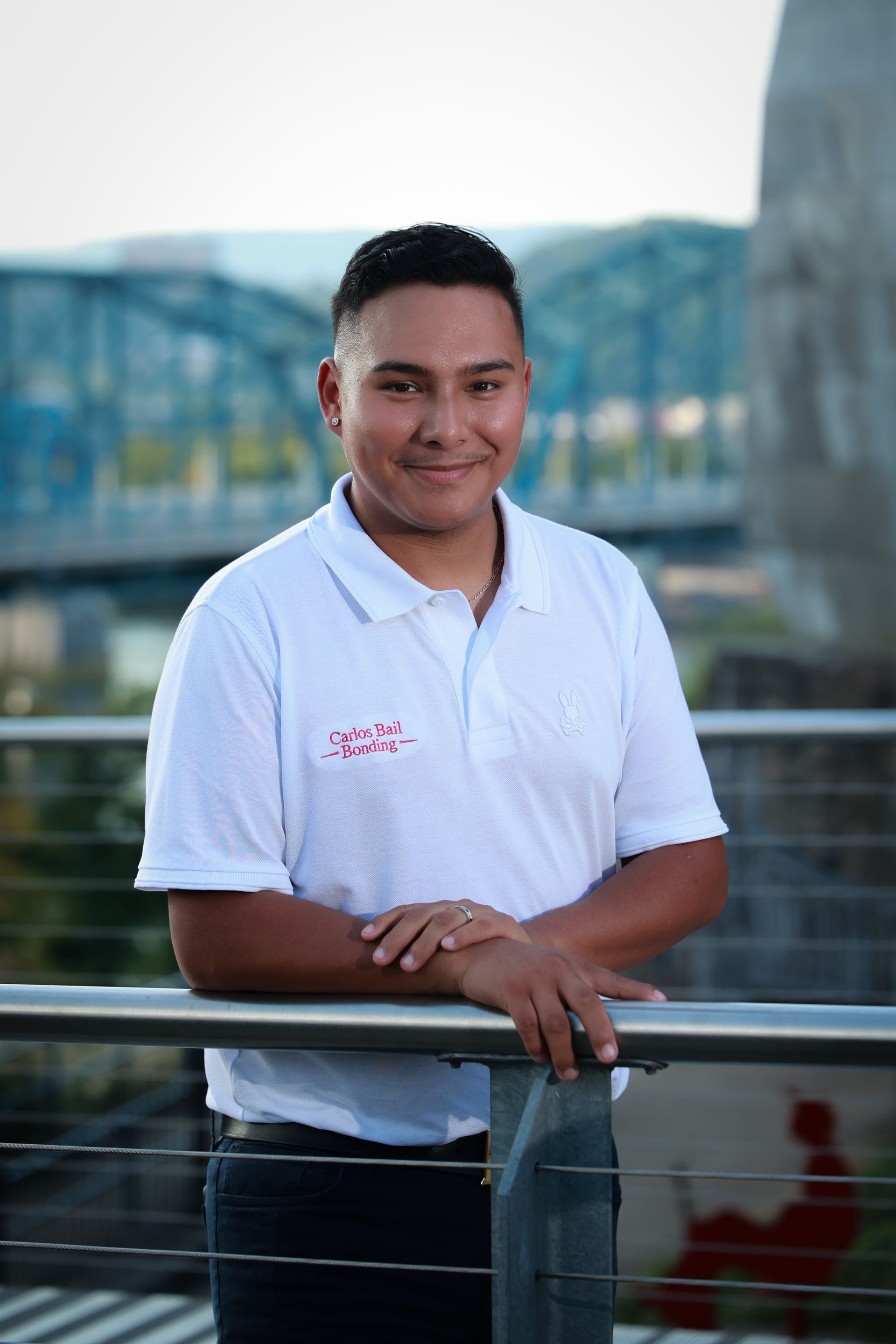 Galdino in a white shirt is leaning on a railing.