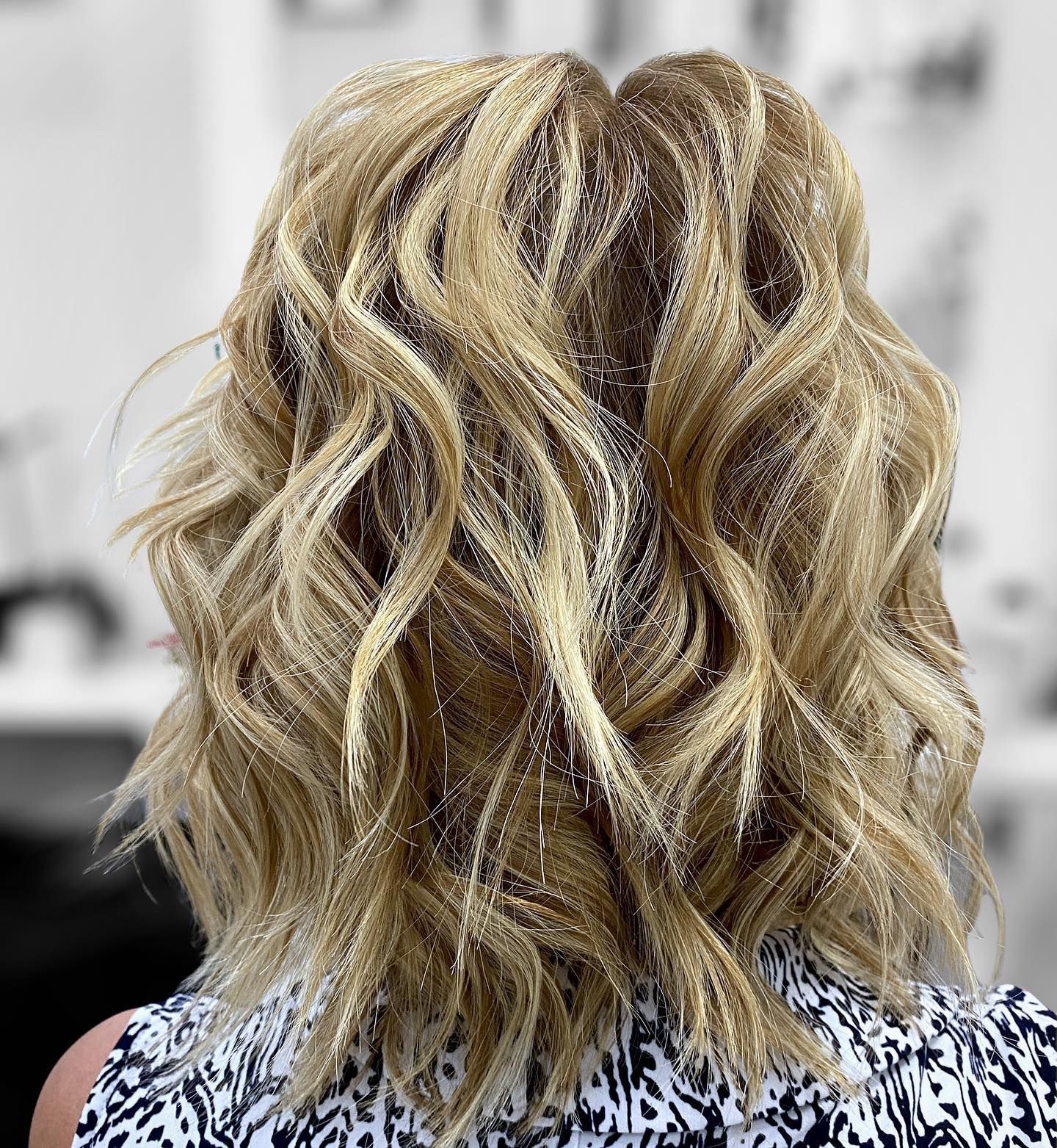 Blonde wavy hair with sparkle strands, rear view.