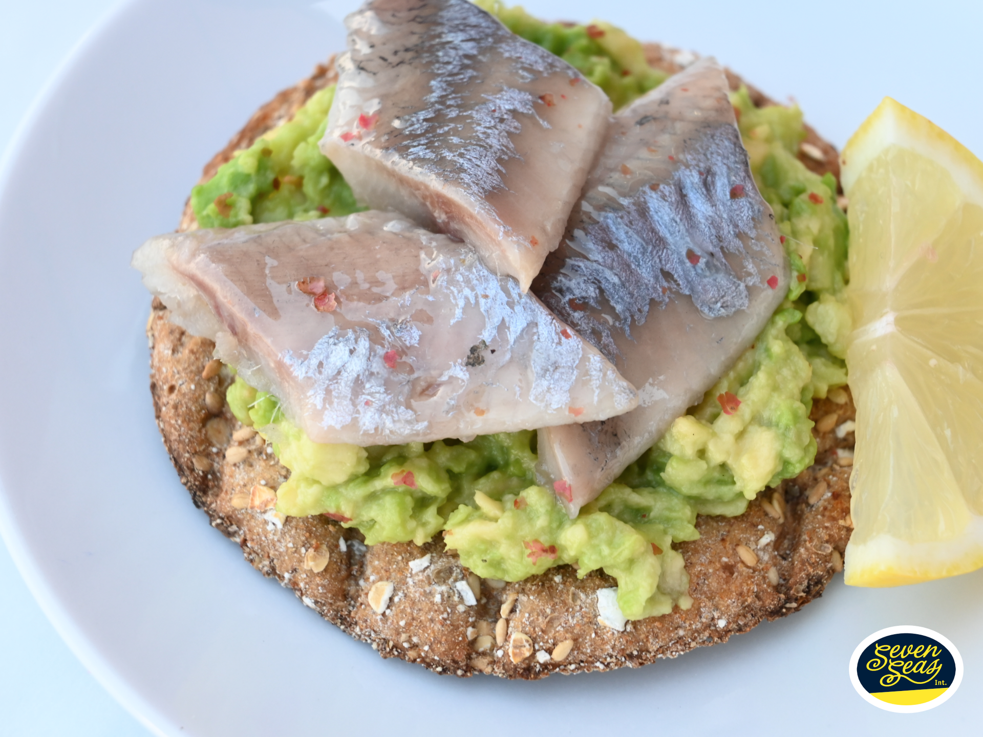 Hollandse Nieuwe haring recept met avocado en peper op een volkoren cracker met citroen