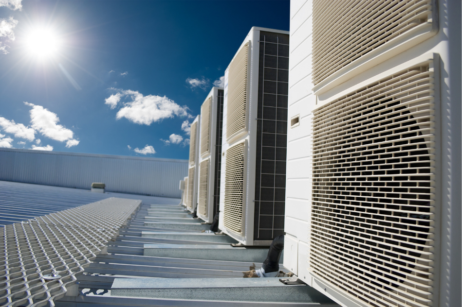 A row of air conditioners on the roof of a building.