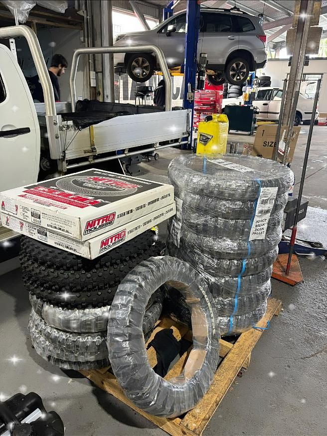 A Stack of Tires Sitting on Top of A Wooden Pallet in A Garage — Lismore Car Repairs in Lismore, NSW