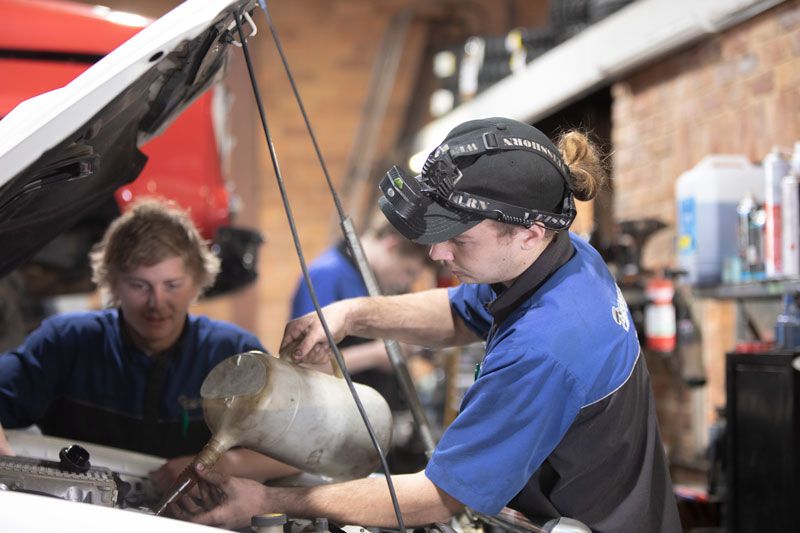Two Mechanics Are Working on A Car in A Garage — Lismore Car Repairs in Lismore, NSW