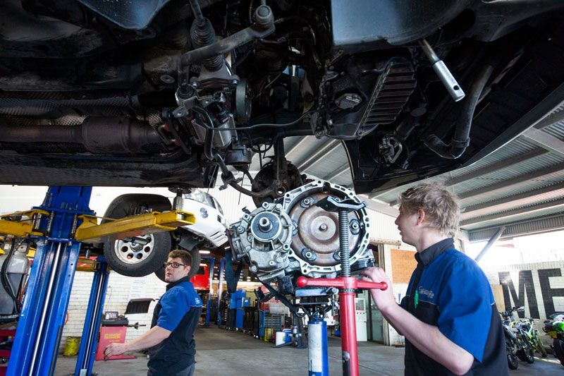 Two Men Are Working on The Underside of A Car in A Garage — Lismore Car Repairs in Lismore, NSW