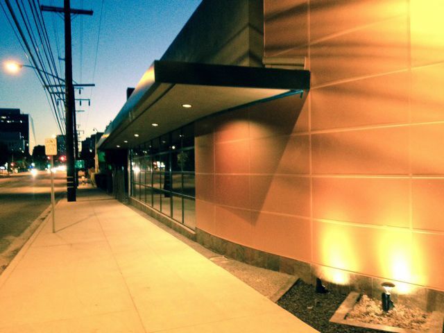 A sidewalk leading to a building with a canopy over it