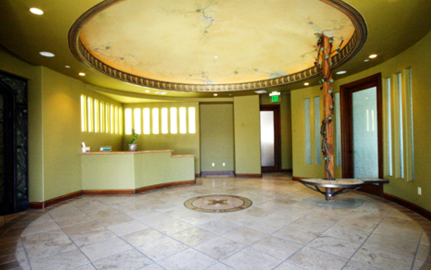 A large empty room with a circular tile floor and a circular ceiling.