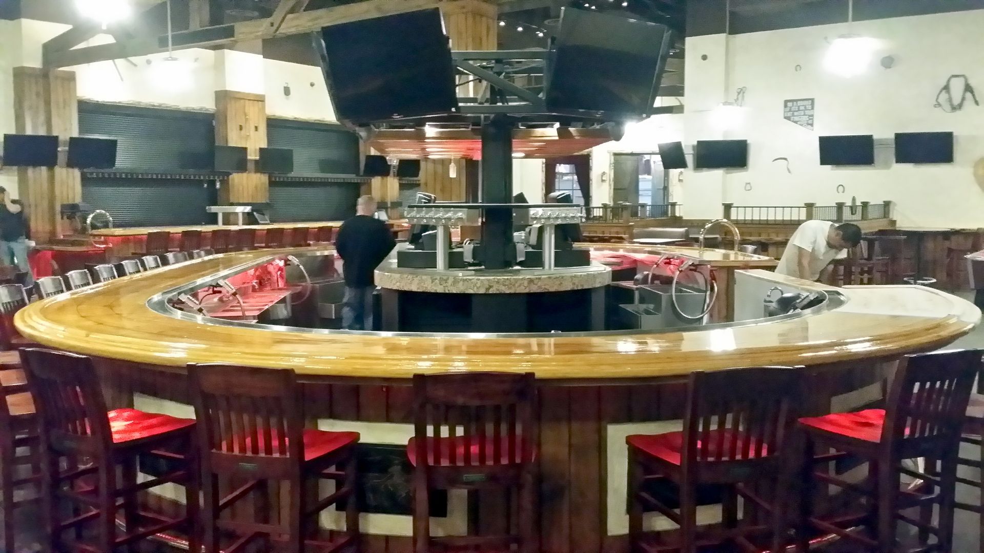 A restaurant with a long wooden bar and stools