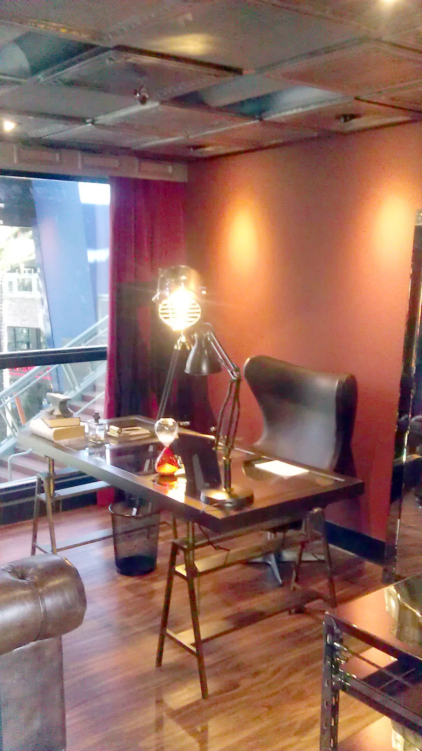 A living room with a desk , chair and lamp