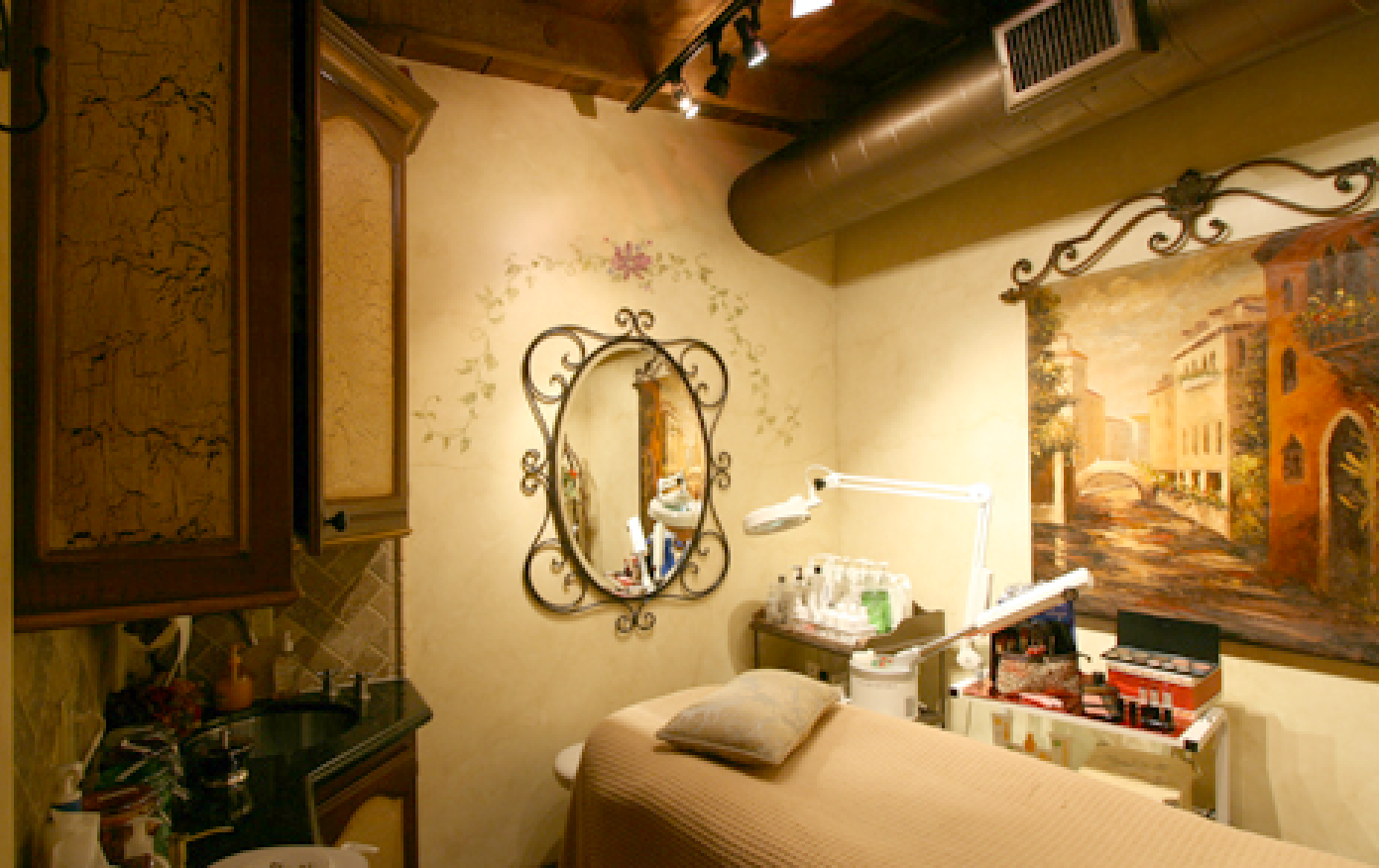 A room with a bed a mirror and a painting on the wall