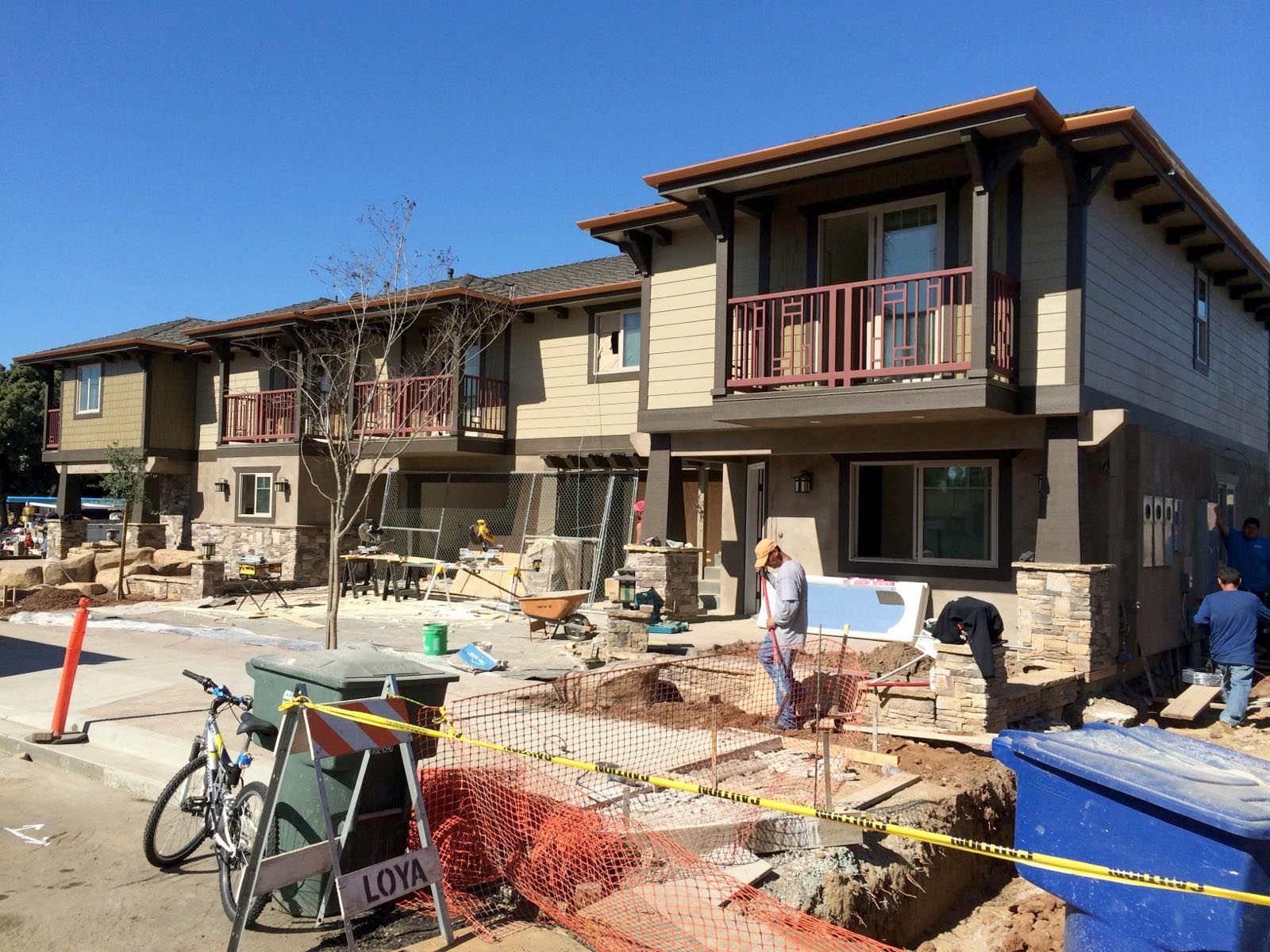 A bicycle is parked in front of a building that is under construction