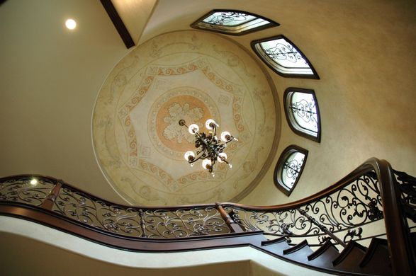 A spiral staircase with a chandelier hanging from the ceiling