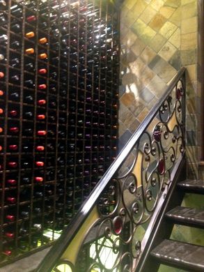 A staircase leading up to a wine cellar filled with lots of wine bottles