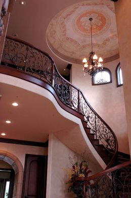 A spiral staircase with a chandelier hanging from the ceiling