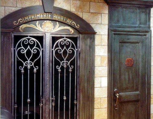 A door with a wrought iron gate and a brick wall behind it