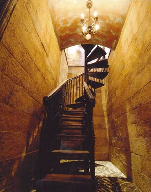 A spiral staircase with a chandelier hanging from the ceiling