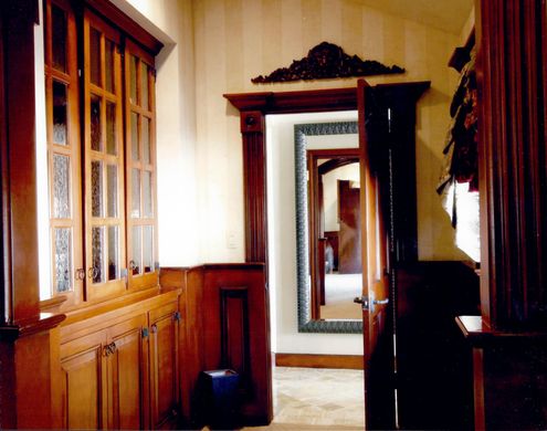 A hallway with wooden cabinets and a mirror