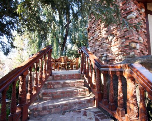 Stairs leading up to a brick building with a wooden railing