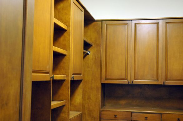 A kitchen with lots of wooden cabinets and shelves