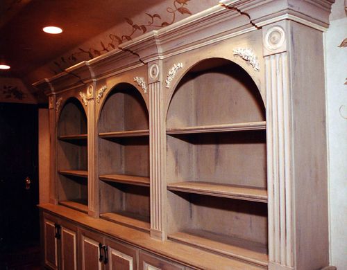 A bookcase with arched shelves and columns