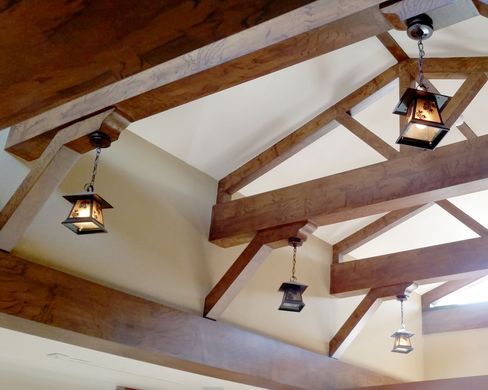 A ceiling with wooden beams and lanterns hanging from it