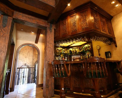 A wooden bar in a room with a clock on the wall