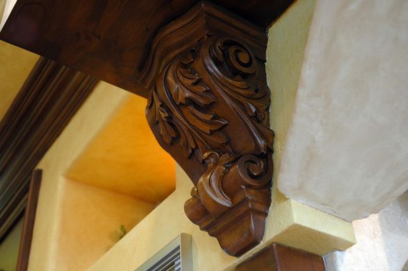 A close up of a carved wooden corner on a building