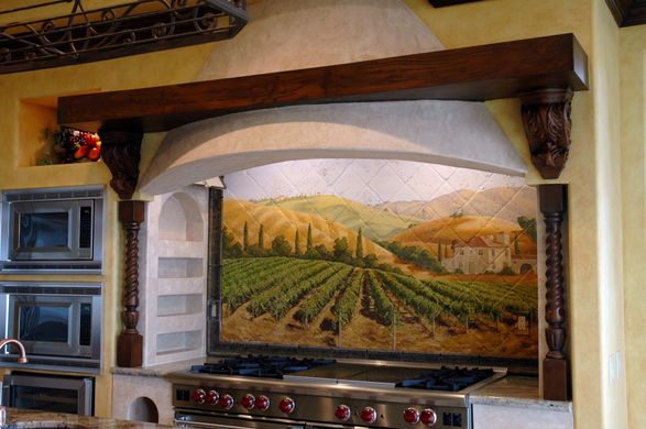 A kitchen with a painting of a vineyard on the wall above the stove